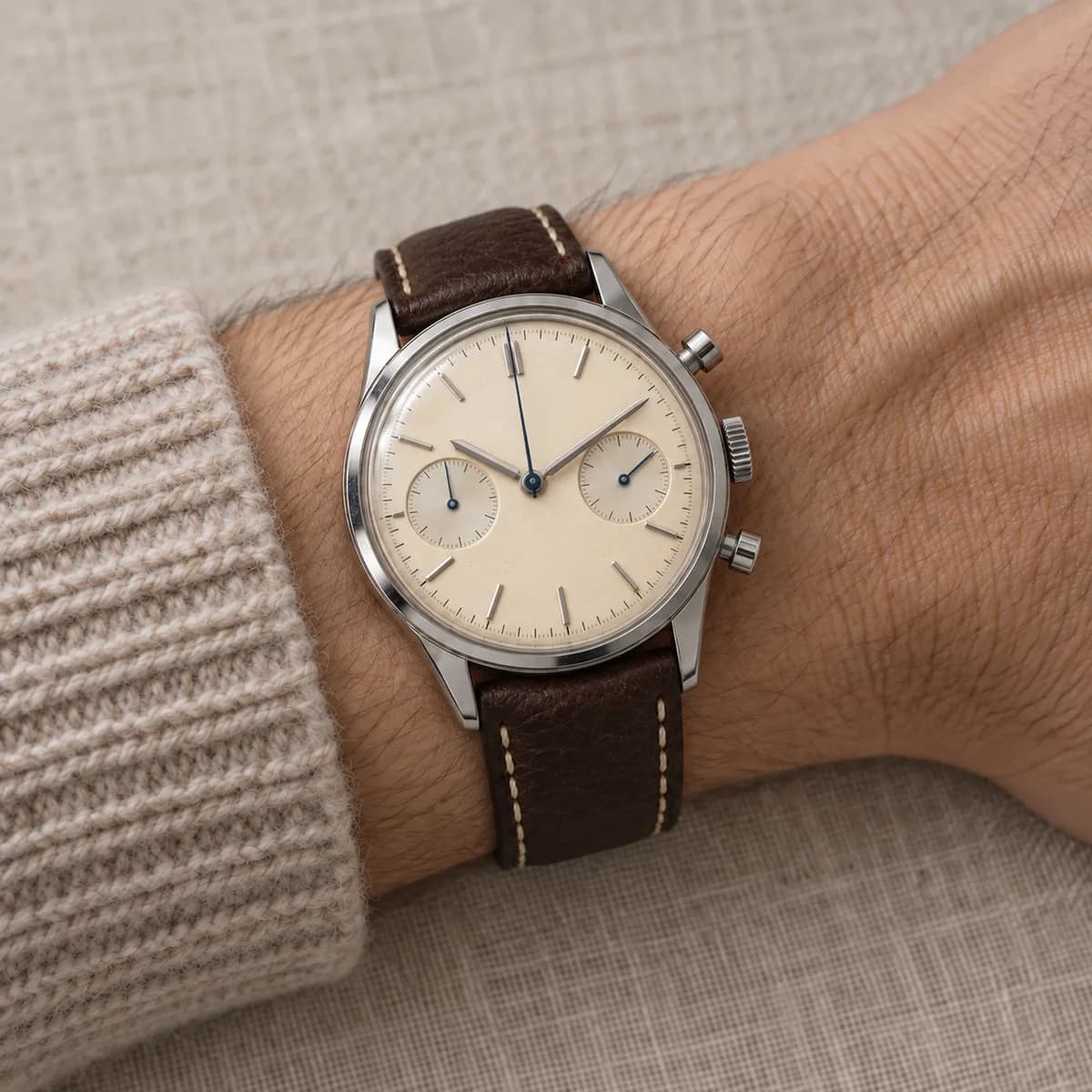 The chronograph worn on a wrist above a wool cuff