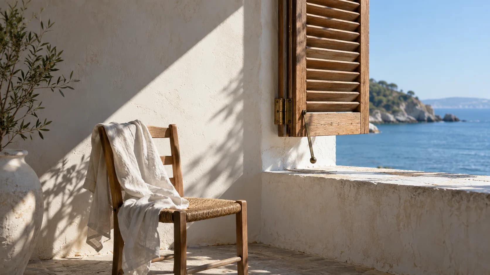 A half-open shutter shaping a narrow plane of light, with an empty chair below