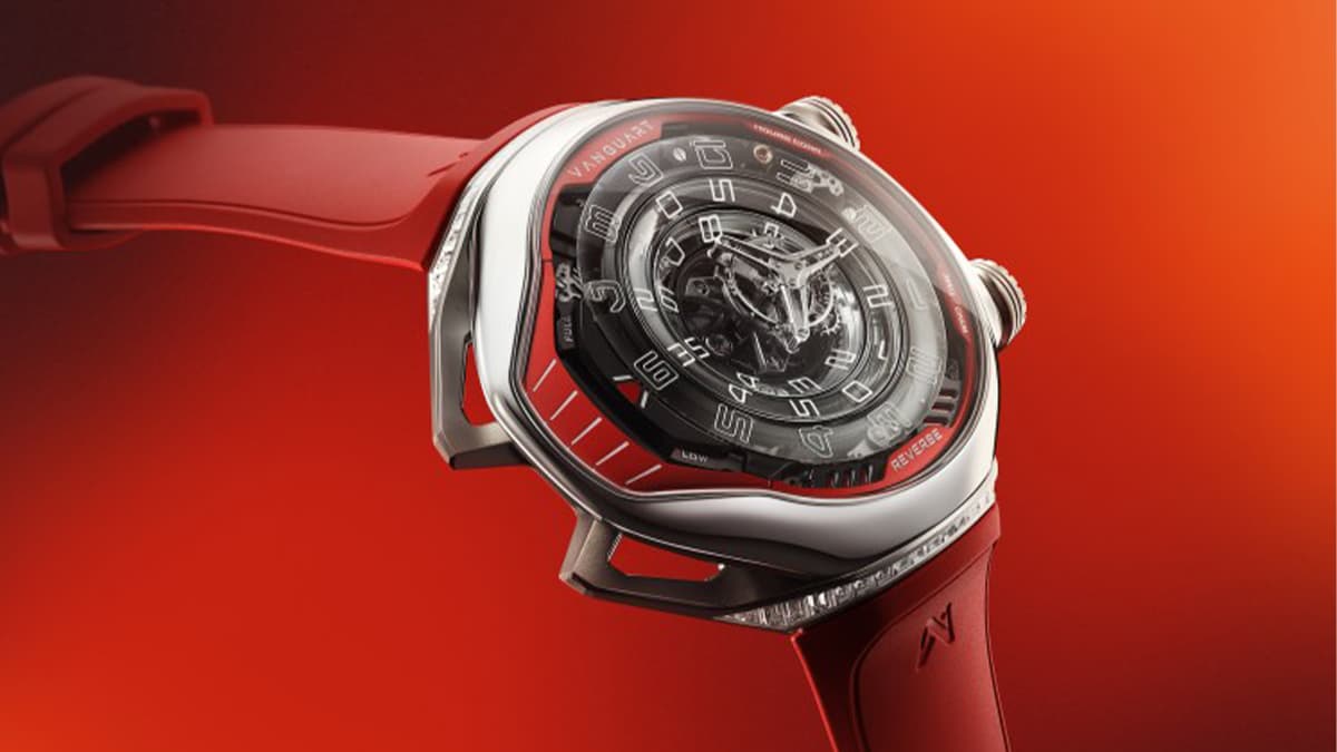 A futuristic red wristwatch with a transparent dial and exposed mechanisms on a red background.