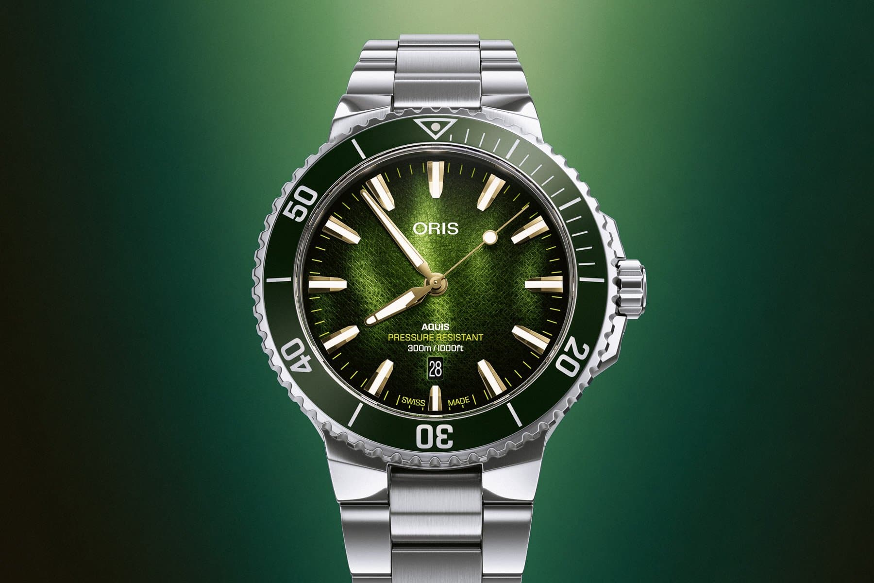 A stainless steel wristwatch with a green textured dial and rotating bezel on a matching bracelet.